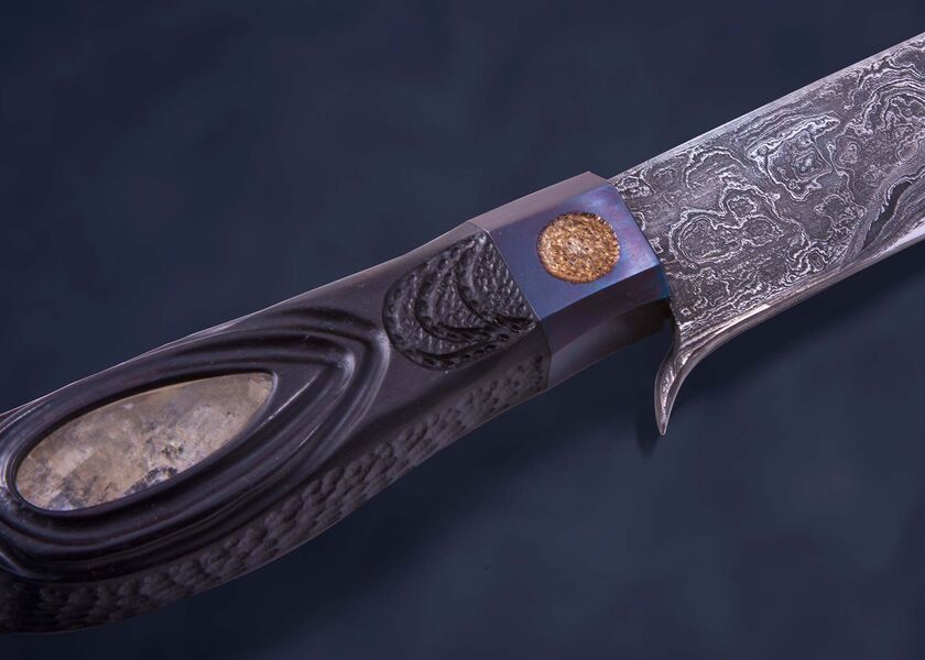 Skraeling Biter Damascus Fighter with carved raven close up